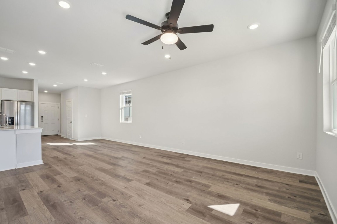 163 Two Bits Lane Elgin, TX 78621 - Photo 6 of 34 a view of an empty room with wooden floor and a ceiling fan
