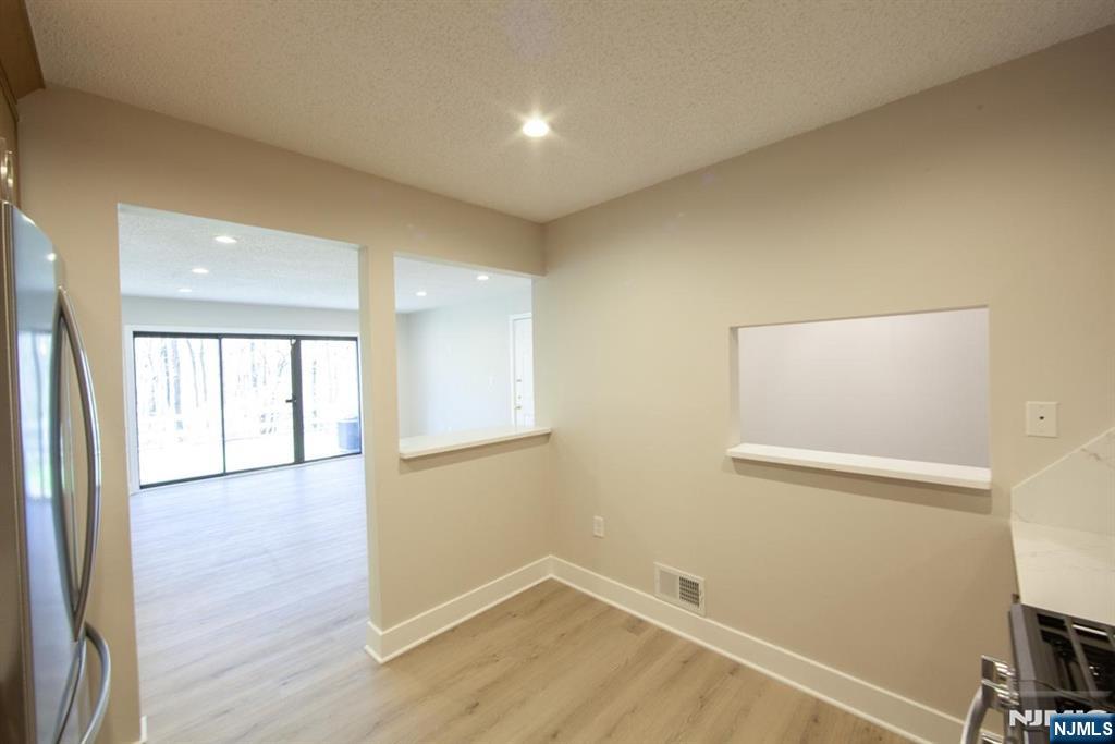 327 Penns Way Bernards, NJ 07920 - Photo 11 of 23 a view of an empty room with wooden floor and a window