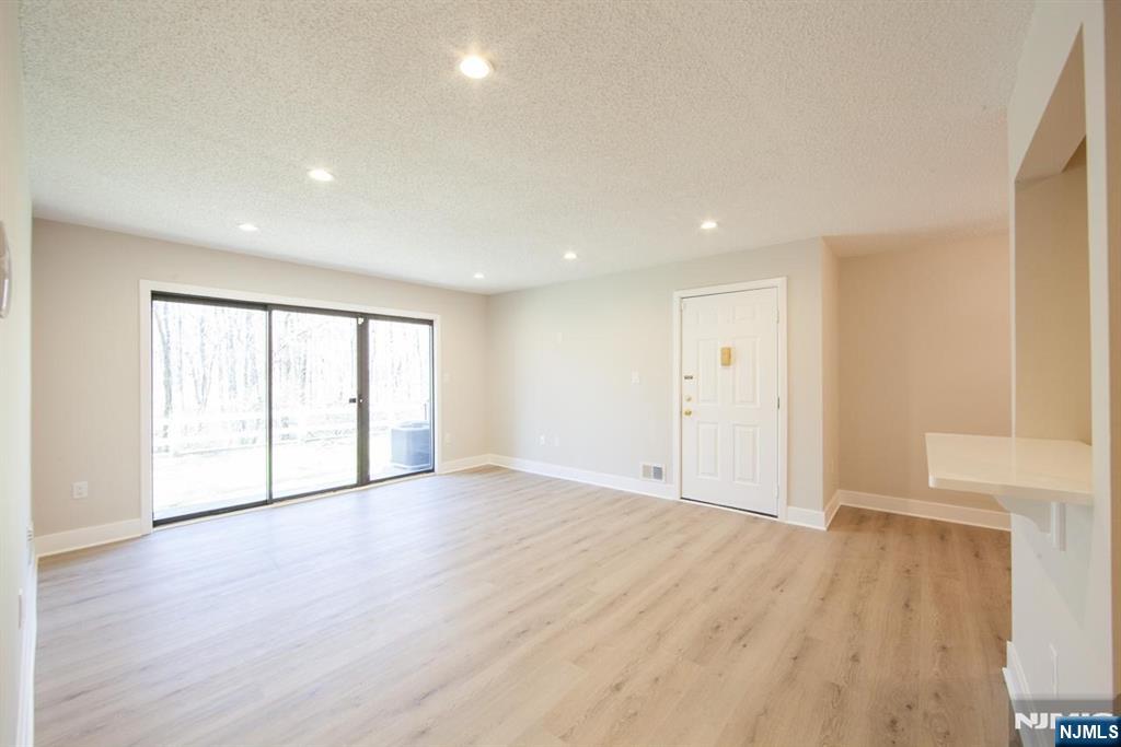 327 Penns Way Bernards, NJ 07920 - Photo 9 of 23 a view of an empty room with wooden floor and a window