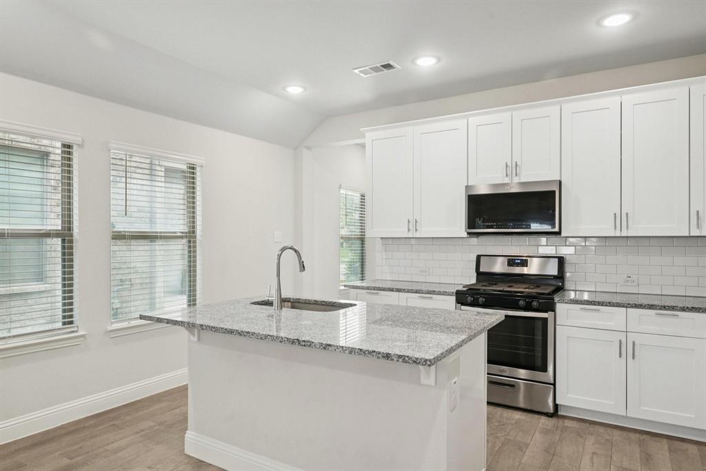 1685 Timpson Drive Forney, TX 75126 - Photo 12 of 36 a kitchen with granite countertop white cabinets and a stainless steel appliances