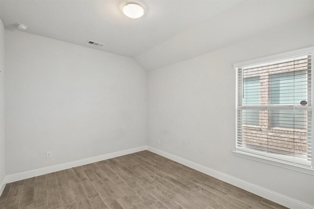 1685 Timpson Drive Forney, TX 75126 - Photo 17 of 36 a view of an empty room with wooden floor and a window