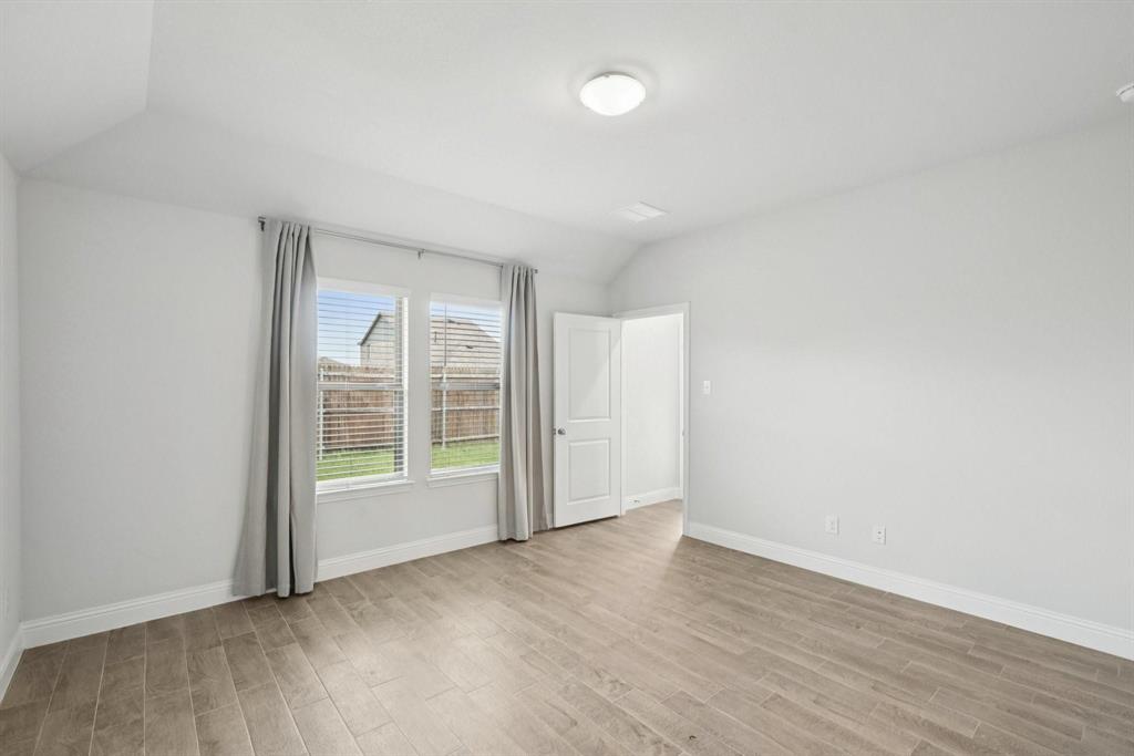 1685 Timpson Drive Forney, TX 75126 - Photo 21 of 36 an empty room with wooden floor and windows