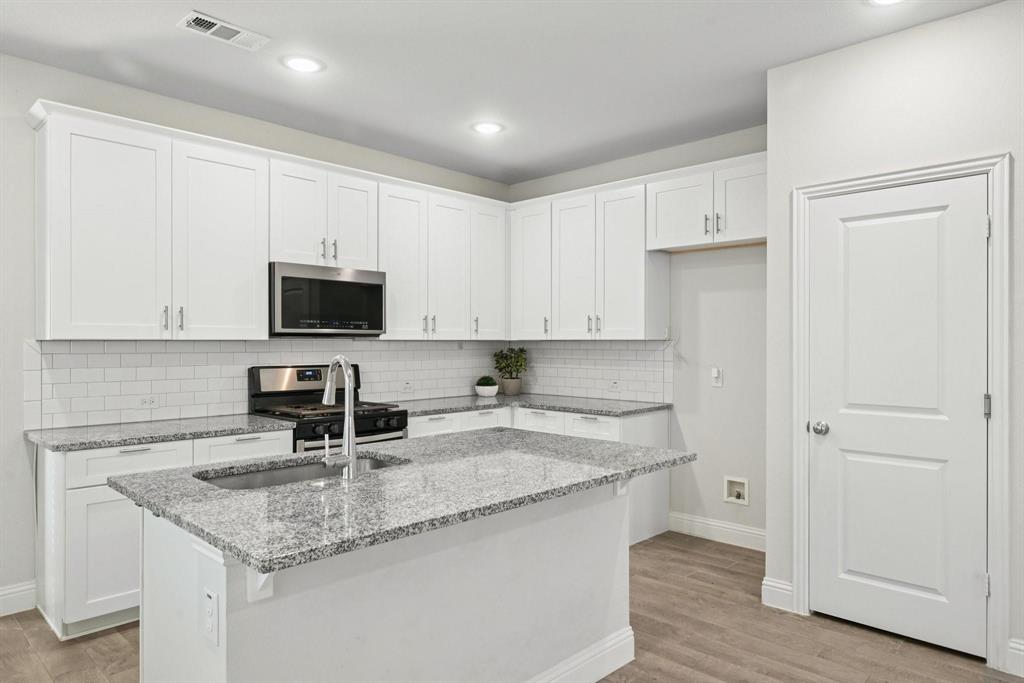 1685 Timpson Drive Forney, TX 75126 - Photo 6 of 36 a kitchen with stainless steel appliances granite countertop a sink a microwave a refrigerator and white cabinets