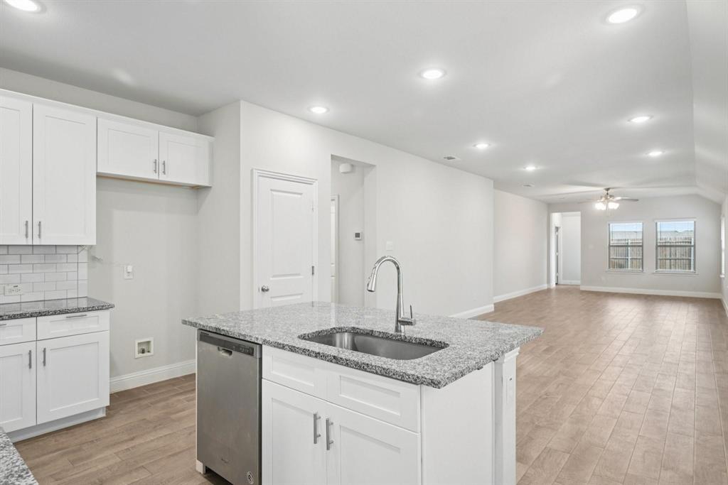 1685 Timpson Drive Forney, TX 75126 - Photo 7 of 36 a kitchen with stainless steel appliances granite countertop a sink a stove and white cabinets with wooden floor