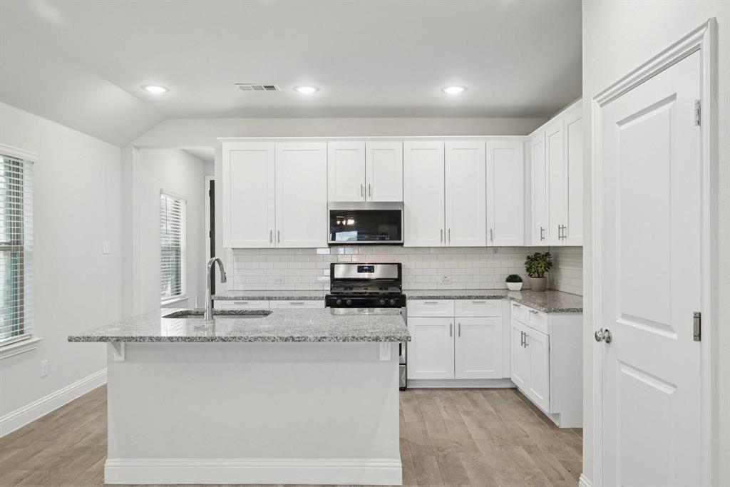 1685 Timpson Drive Forney, TX 75126 - Photo 9 of 36 a kitchen with stainless steel appliances granite countertop a stove a sink and a refrigerator