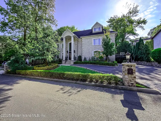 a front view of a house with a yard and potted plants