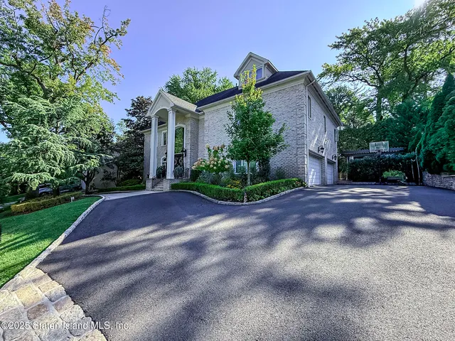 a view of a house with a yard and potted plants