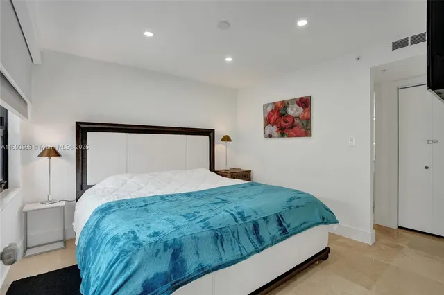 a bedroom with a large bed and a window