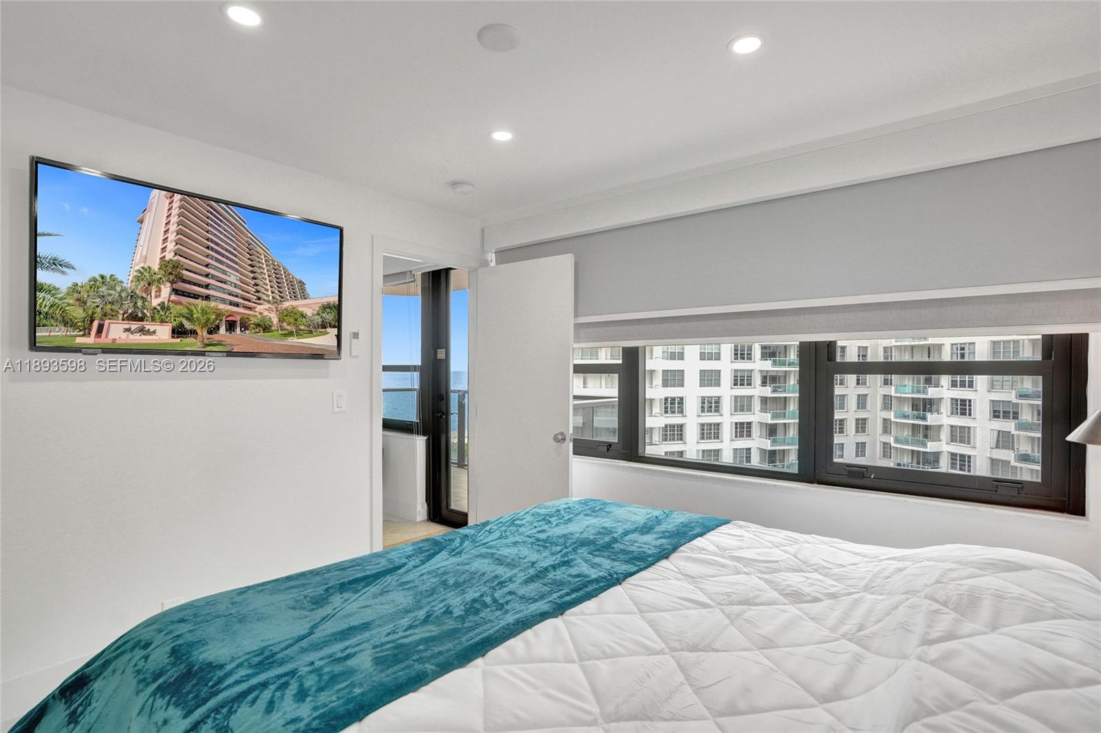 5225 Collins Avenue, Unit 1411 Miami Beach, FL 33140 - Photo 18 of 36 a bedroom with a large bed and a large window