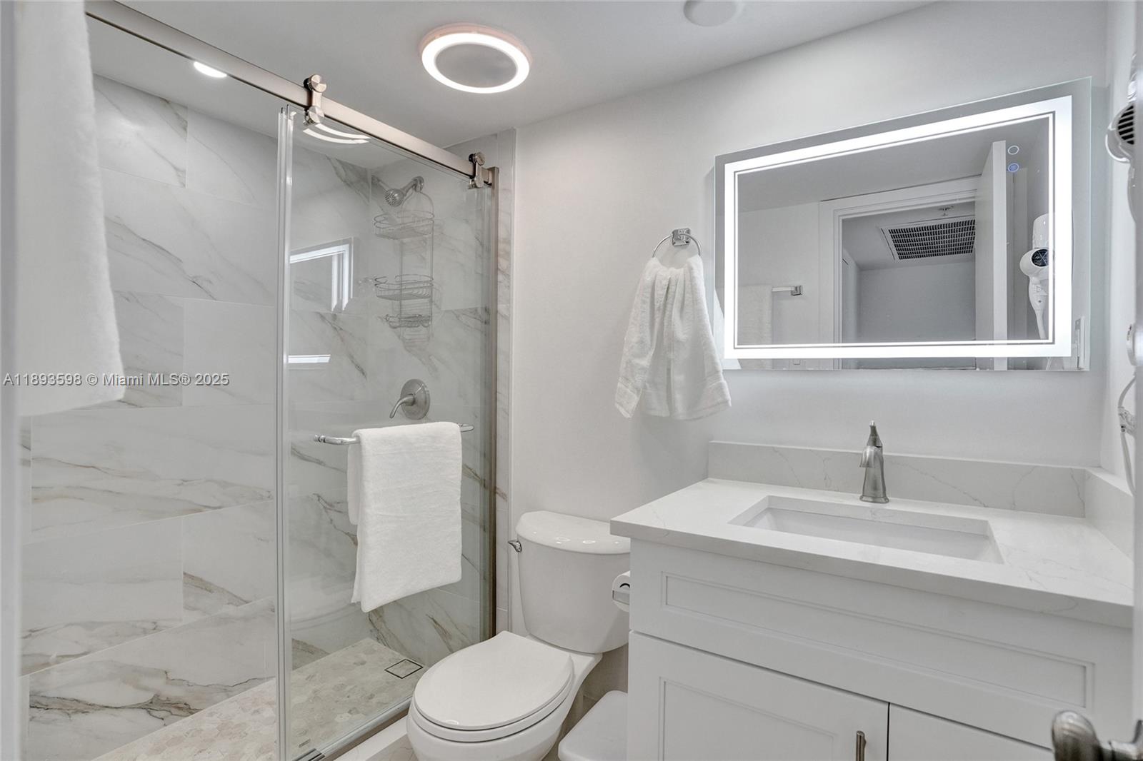 5225 Collins Avenue, Unit 1411 Miami Beach, FL 33140 - Photo 19 of 34 a bathroom with a sink a toilet and shower