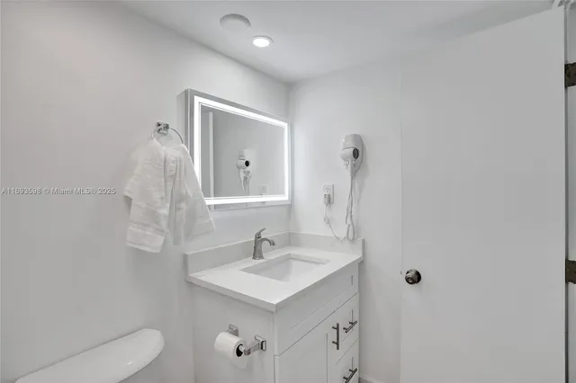 a bathroom with a sink a toilet and mirror