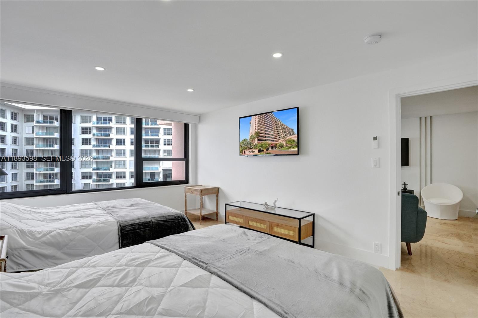 5225 Collins Avenue, Unit 1411 Miami Beach, FL 33140 - Photo 21 of 36 a bedroom with a large bed and a window