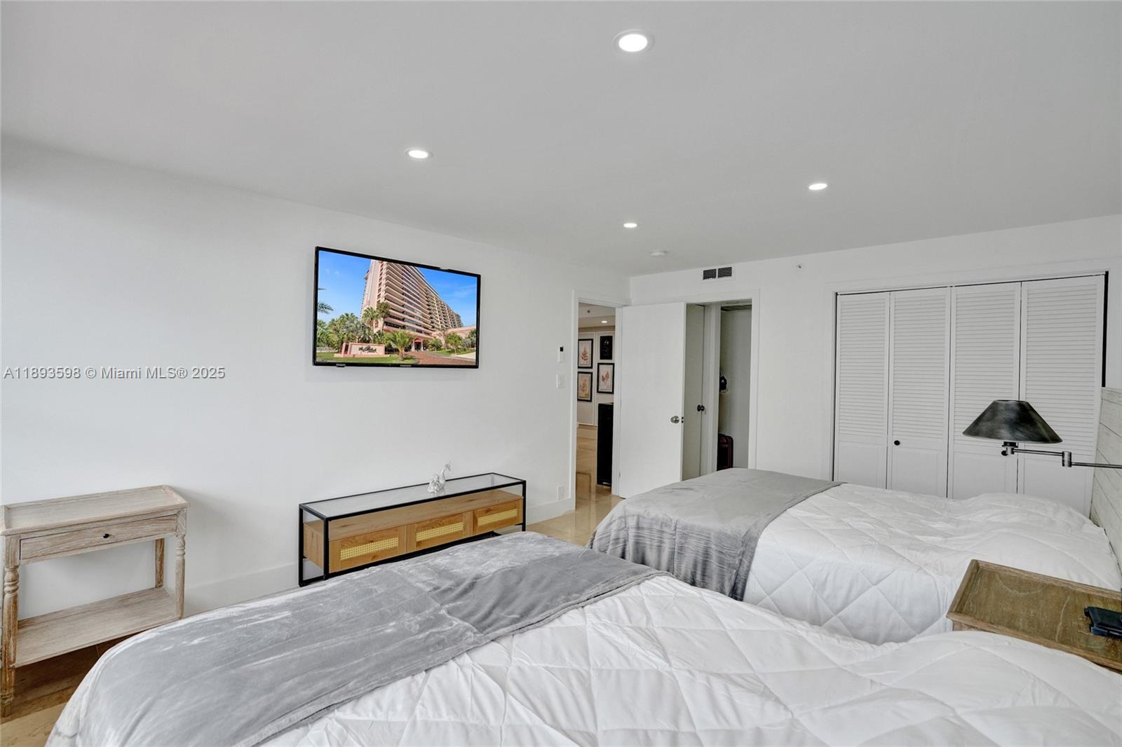 5225 Collins Avenue, Unit 1411 Miami Beach, FL 33140 - Photo 25 of 34 a bedroom with two bed and a painting on the wall