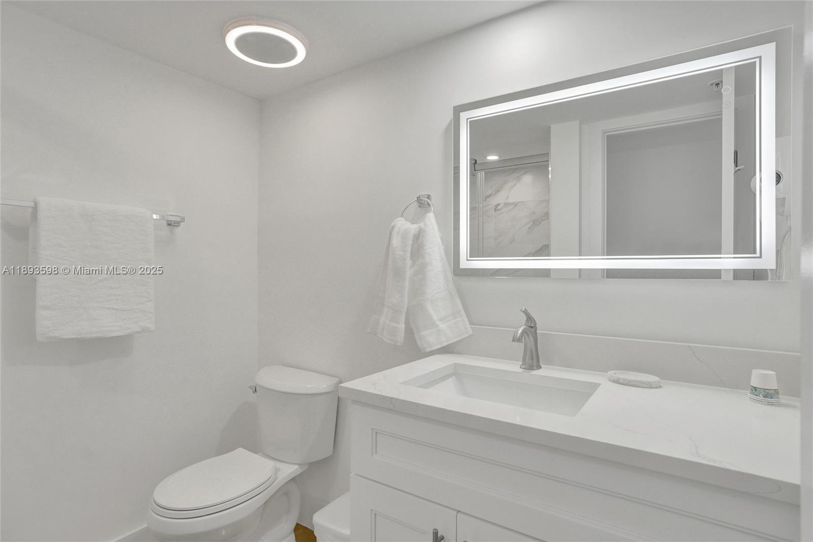 5225 Collins Avenue, Unit 1411 Miami Beach, FL 33140 - Photo 26 of 34 a bathroom with a sink a toilet and mirror
