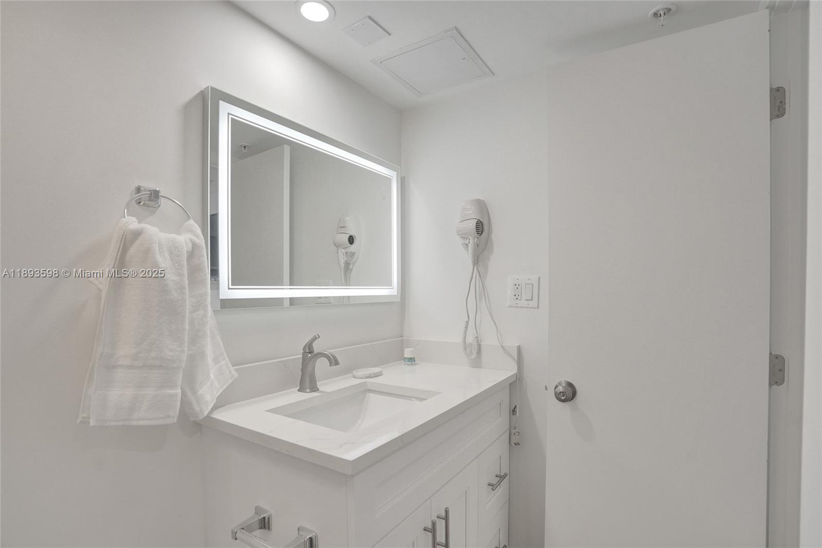 5225 Collins Avenue, Unit 1411 Miami Beach, FL 33140 - Photo 28 of 34 a bathroom with a sink and a mirror