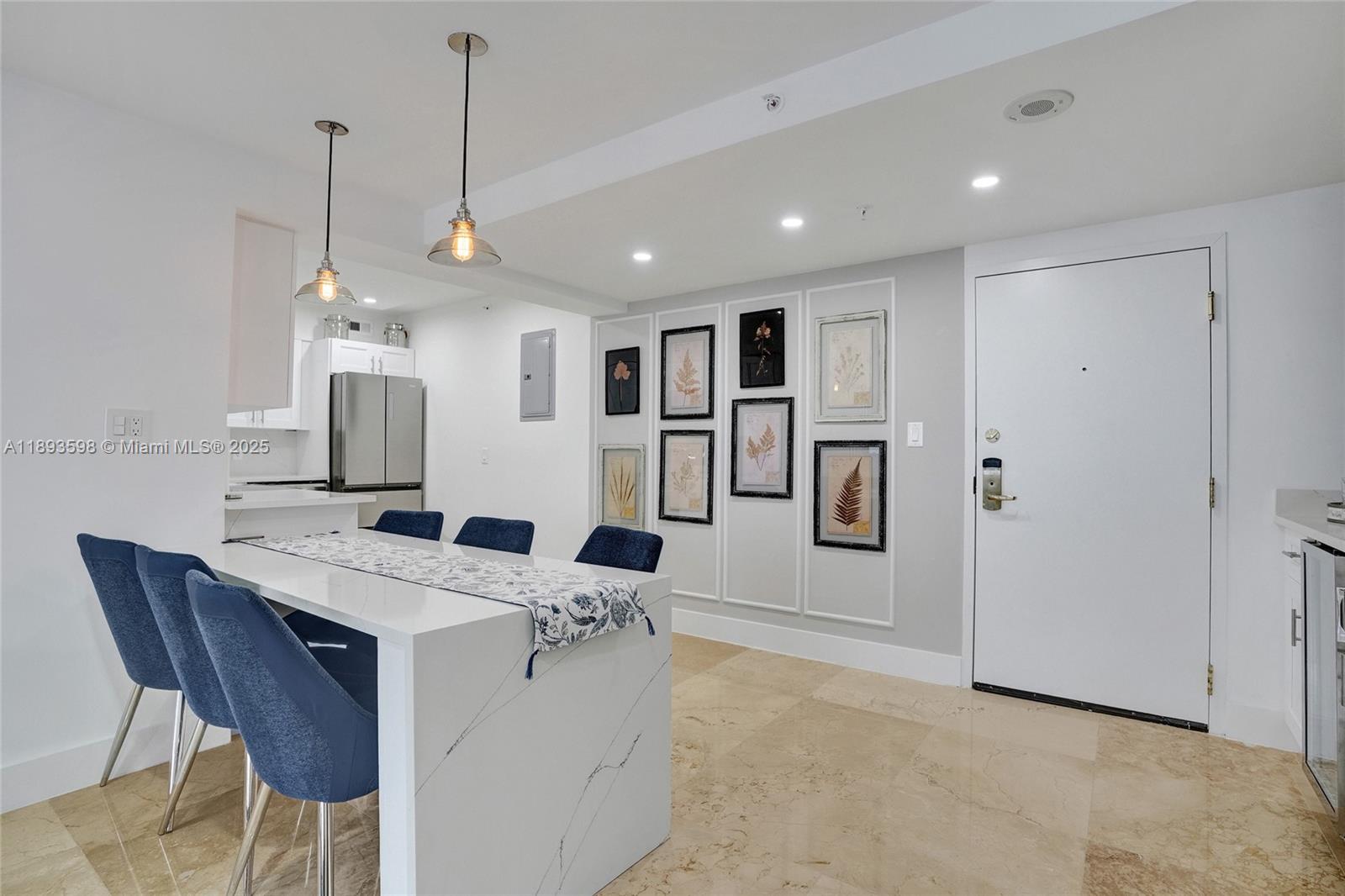5225 Collins Avenue, Unit 1411 Miami Beach, FL 33140 - Photo 3 of 34 a kitchen with stainless steel appliances kitchen island granite countertop a refrigerator a oven a sink a dining table and chairs with wooden floor