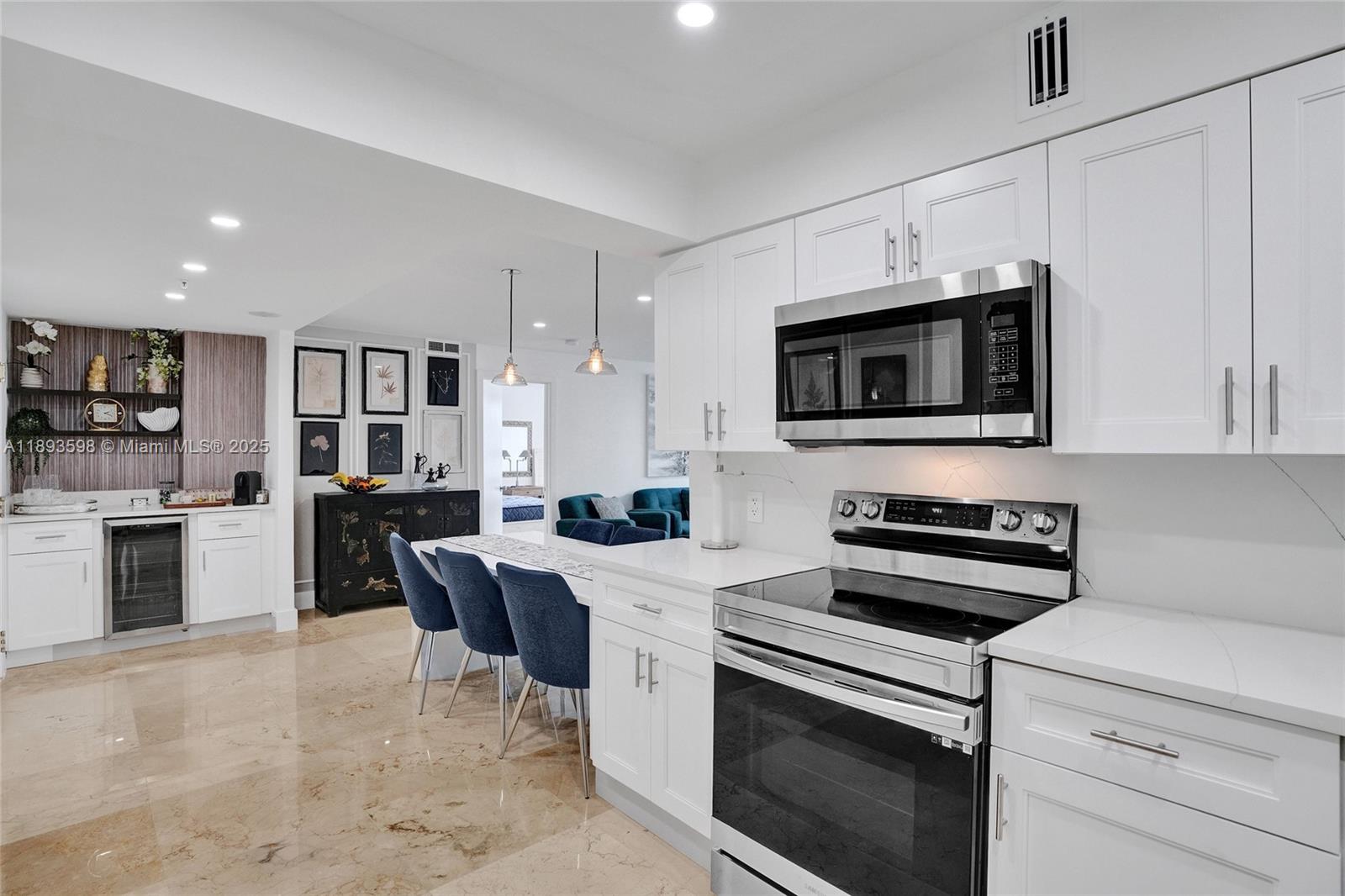 5225 Collins Avenue, Unit 1411 Miami Beach, FL 33140 - Photo 4 of 34 a kitchen with stainless steel appliances a stove sink microwave and cabinets