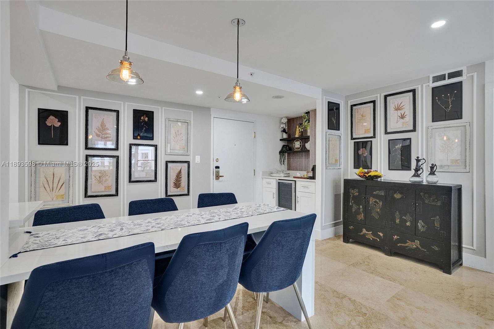 5225 Collins Avenue, Unit 1411 Miami Beach, FL 33140 - Photo 7 of 34 a large kitchen with granite countertop a stove a sink dishwasher a dining table and chairs with wooden floor