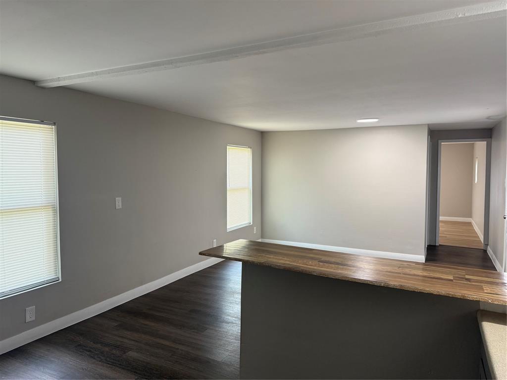 117 Aztec Way West Tawakoni, TX 75474 - Photo 5 of 12 Open concept living space featuring neutral gray walls, dark wood-finish flooring, and white baseboards