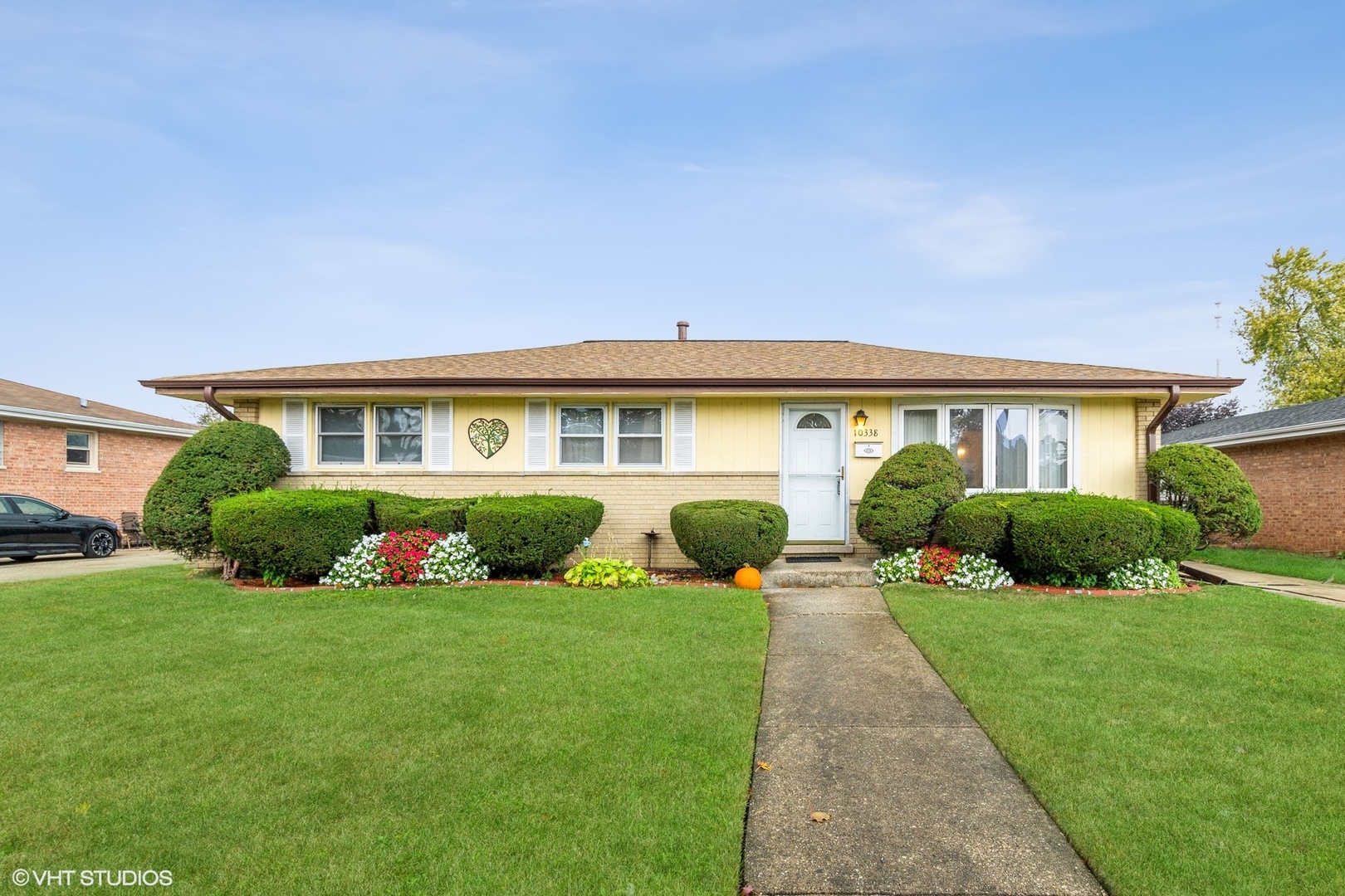 a front view of a house with a yard and potted plants