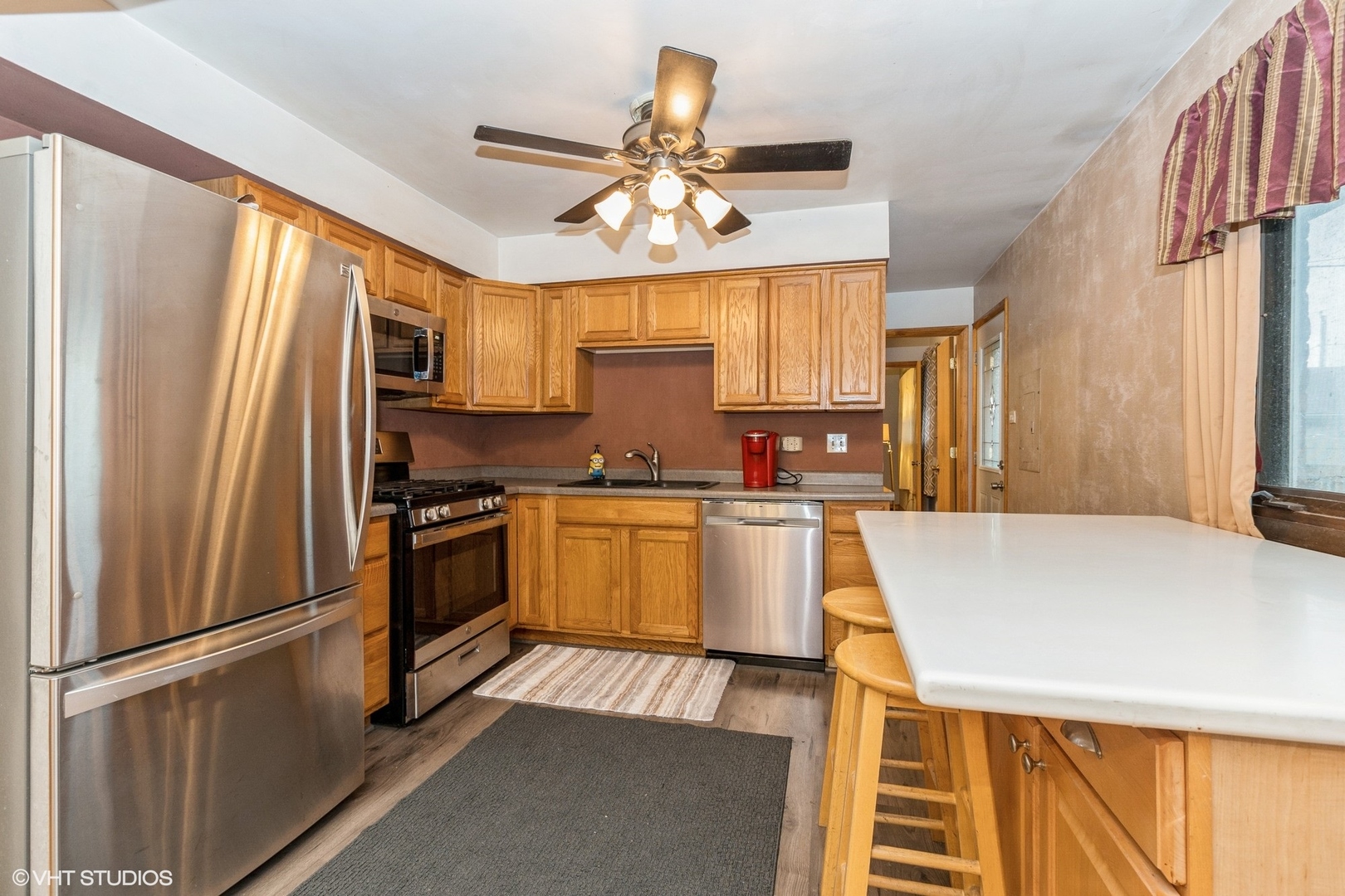 10338 Barnard Drive Chicago Ridge, IL 60415 - Photo 4 of 17 a kitchen with granite countertop a refrigerator a sink dishwasher a stove and white cabinets with wooden floor
