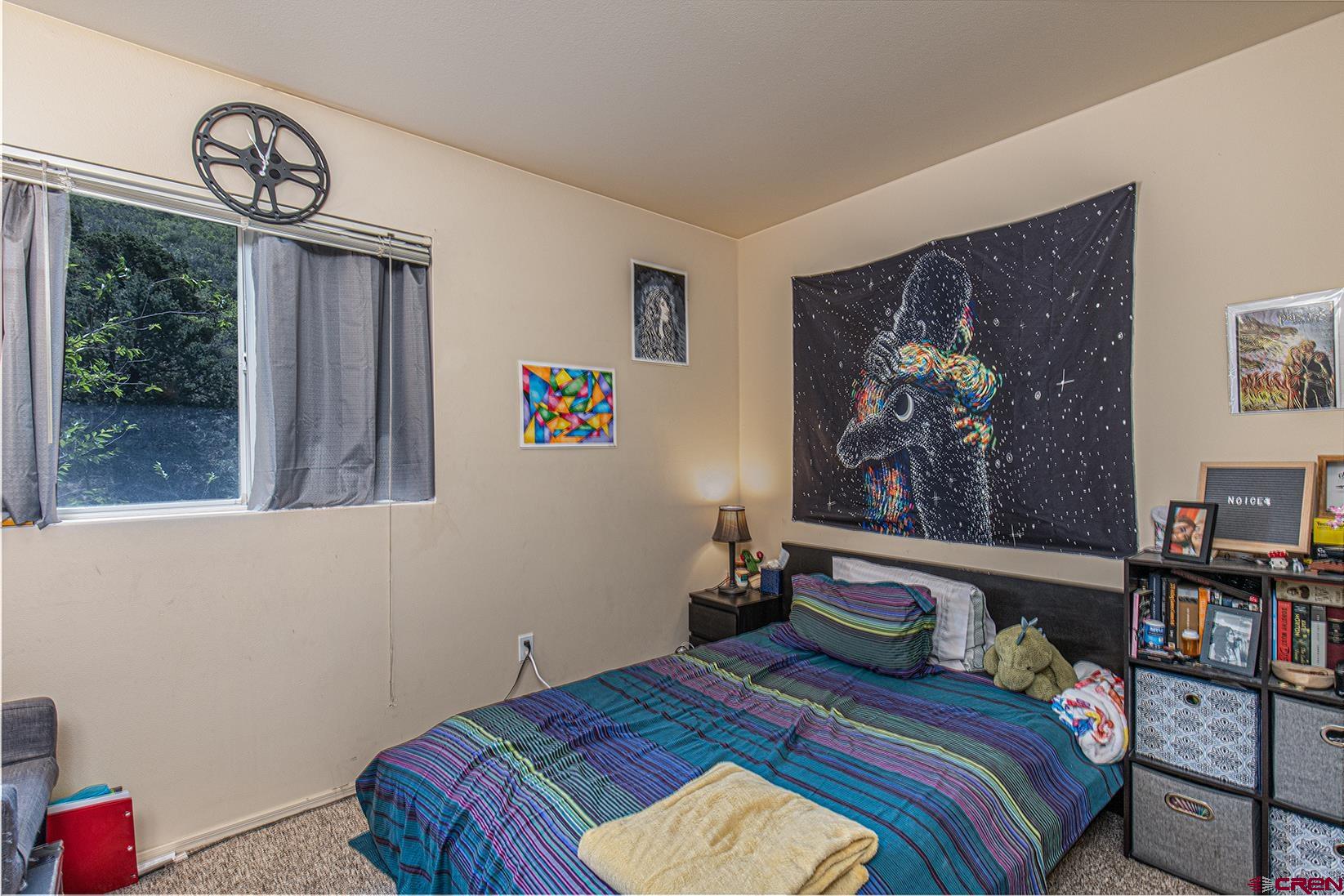 1100 Goeglein Gulch Road, Unit 170 Durango, CO 81301 - Photo 8 of 21 a bedroom with a bed a painting on the wall and a potted plant