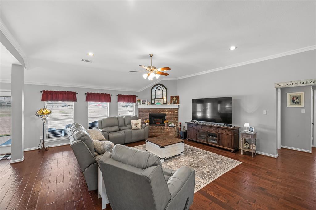 11277 Emerald Ranch Lane Forney, TX 75126 - Photo 12 of 32 a living room with furniture a flat screen tv and wooden floor