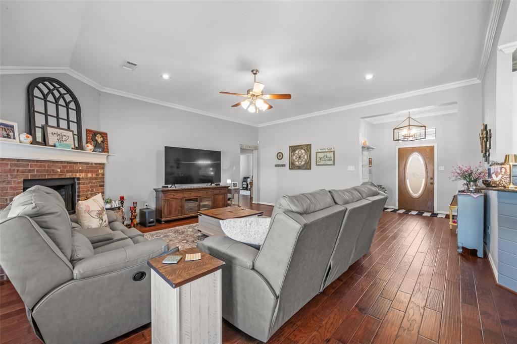 11277 Emerald Ranch Lane Forney, TX 75126 - Photo 13 of 32 a living room with furniture a flat screen tv and a fireplace