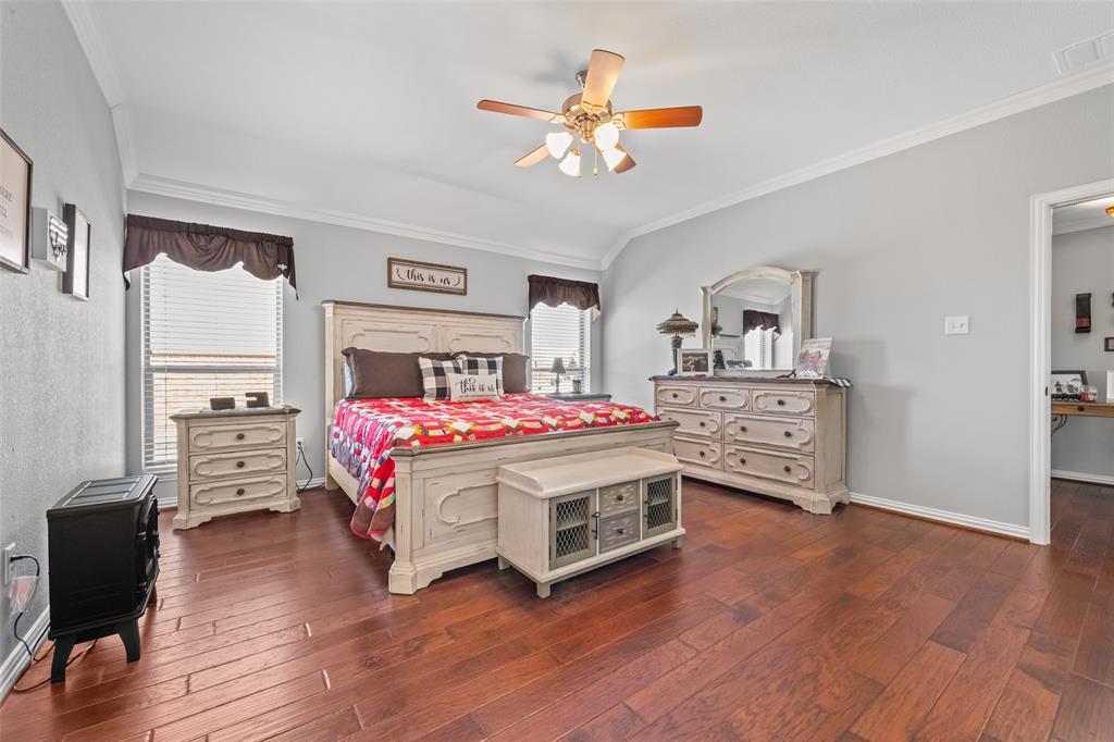 11277 Emerald Ranch Lane Forney, TX 75126 - Photo 15 of 32 a bedroom with a bed and a chandelier