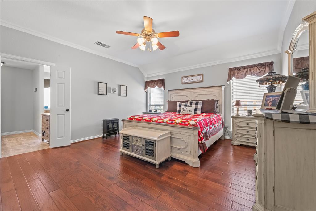 11277 Emerald Ranch Lane Forney, TX 75126 - Photo 16 of 32 a bedroom with a bed and a chandelier