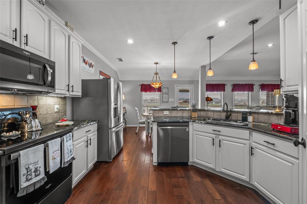 11277 Emerald Ranch Lane Forney, TX 75126 - Photo 8 of 32 a kitchen with stainless steel appliances kitchen island granite countertop a sink stove and refrigerator