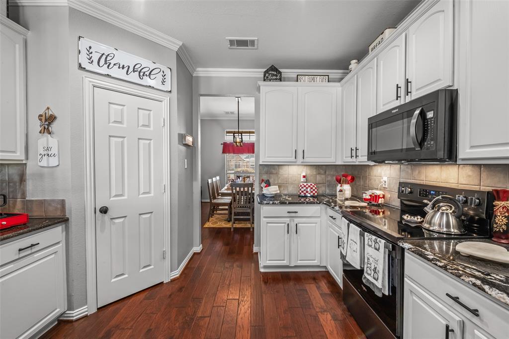 11277 Emerald Ranch Lane Forney, TX 75126 - Photo 10 of 32 a kitchen with stainless steel appliances granite countertop a stove cabinets and wooden floor