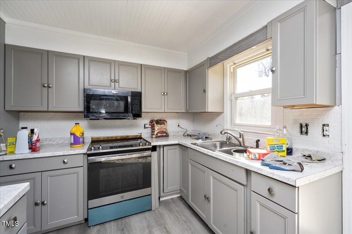 2540 Mayo Lake Road Roxboro, NC 27574 - Photo 10 of 24 a kitchen with sink a microwave and cabinets