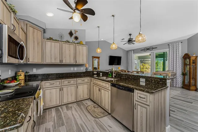 a kitchen with stainless steel appliances granite countertop a stove and cabinets