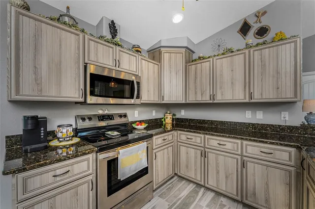 a kitchen with granite countertop white cabinets stainless steel appliances and sink