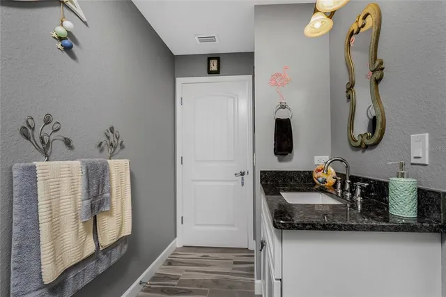 a bathroom with a granite countertop shower a sink and a toilet