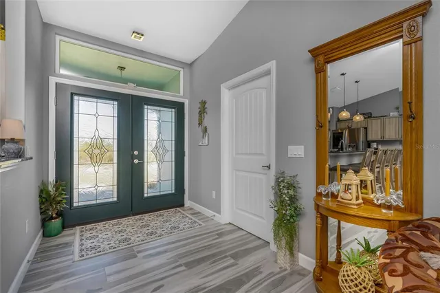 a view of a hallway with wooden floor and a living room