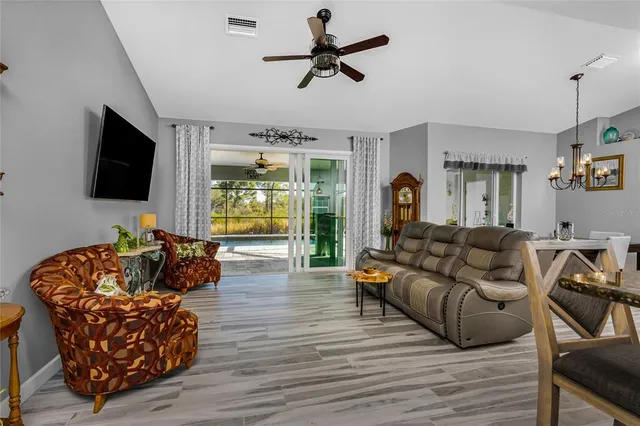 a living room with furniture ceiling fan and a flat screen tv