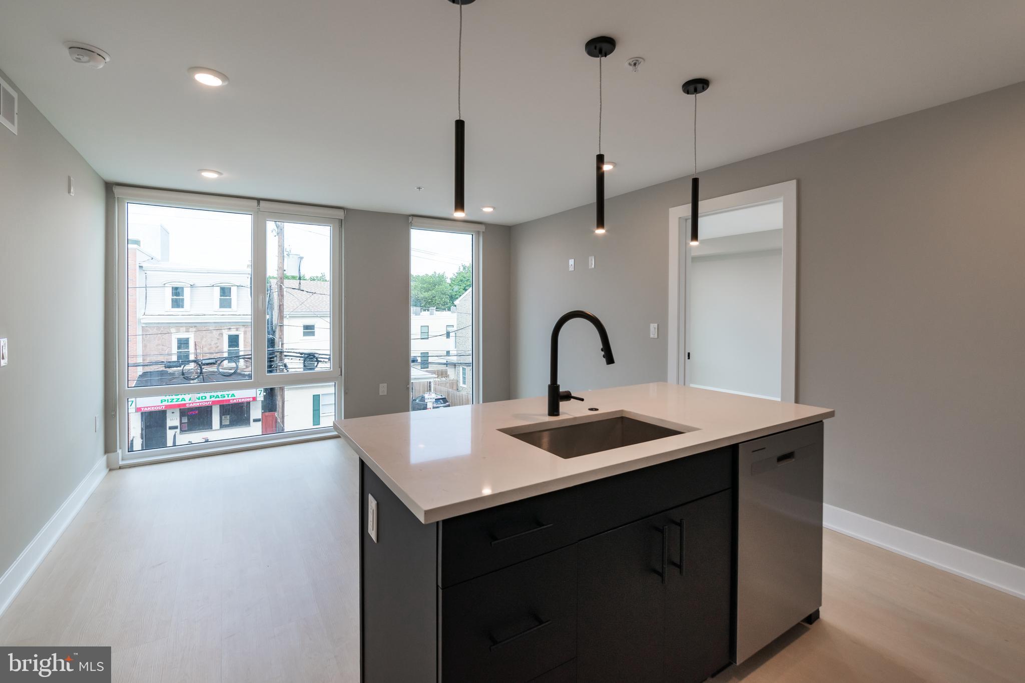 6604 Ridge Avenue, Unit 309 Philadelphia, PA 19128 - Photo 2 of 13 a kitchen with a sink a counter space and a view of kitchen