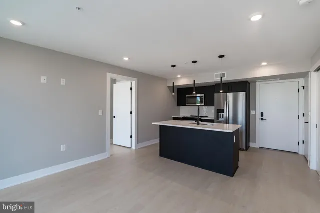 a kitchen with stainless steel appliances a refrigerator and a stove top oven