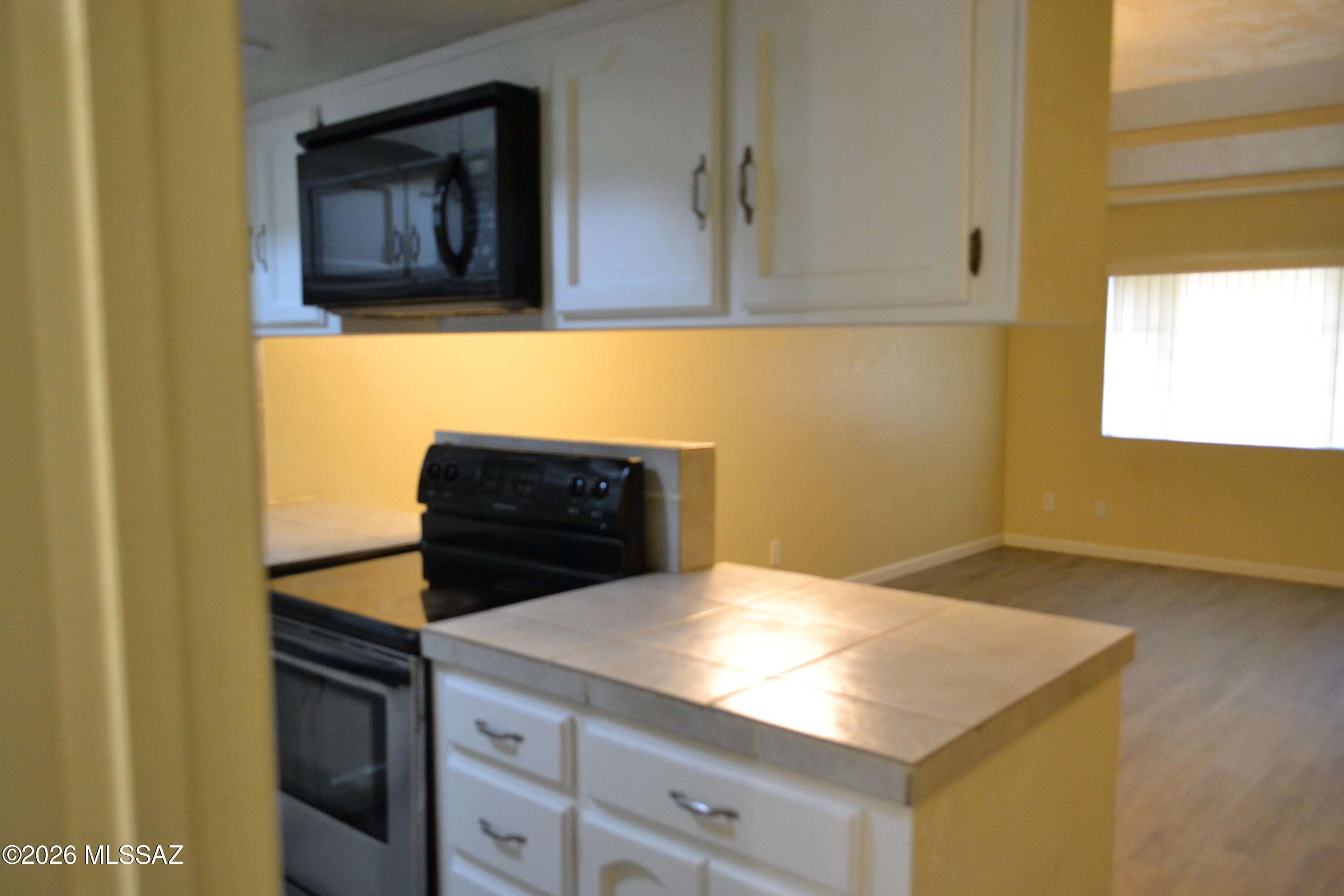 1200 East River Road, Unit D47 Tucson, AZ 85718 - Photo 4 of 13 a kitchen with stainless steel appliances cabinets and wooden floor