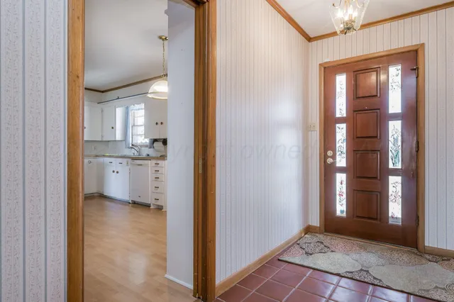 a view of a hallway with wooden floor and a kitchen
