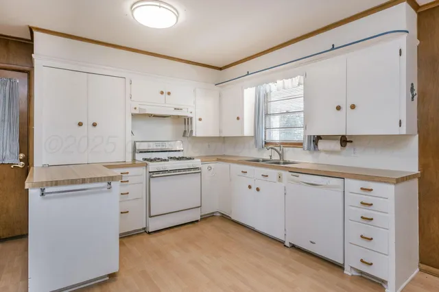 a kitchen with granite countertop white cabinets and white appliances