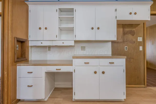 a kitchen with cabinets appliances and a wooden floor