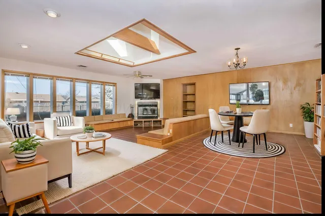 a living room with fireplace furniture and a large window