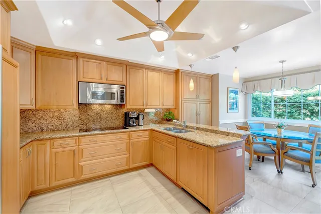 a kitchen with stainless steel appliances granite countertop a refrigerator a stove and a sink with cabinets
