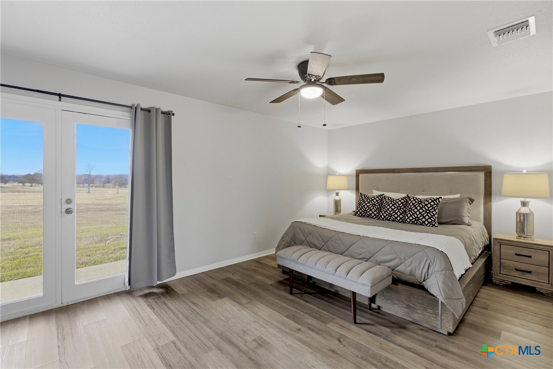 1710 Old Mill Road, Unit 12 Salado, TX 76571 - Photo 26 of 42 a bedroom with a bed and wooden floor