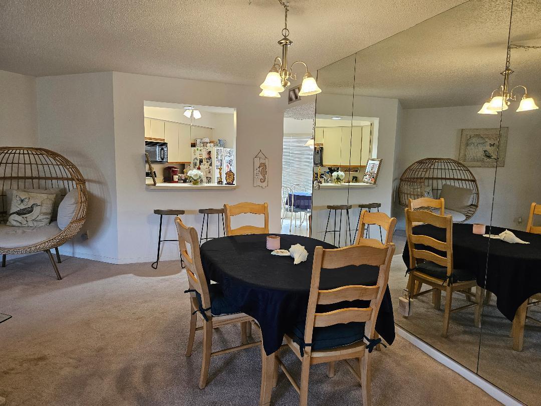 6070 Southeast Martinique Drive, Unit 103 Stuart, FL 34997 - Photo 10 of 30 a view of a dining room with furniture and a chandelier