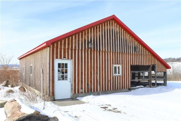 a kitchen with stainless steel appliances granite countertop a refrigerator a sink dishwasher a dining table and chairs with wooden floor