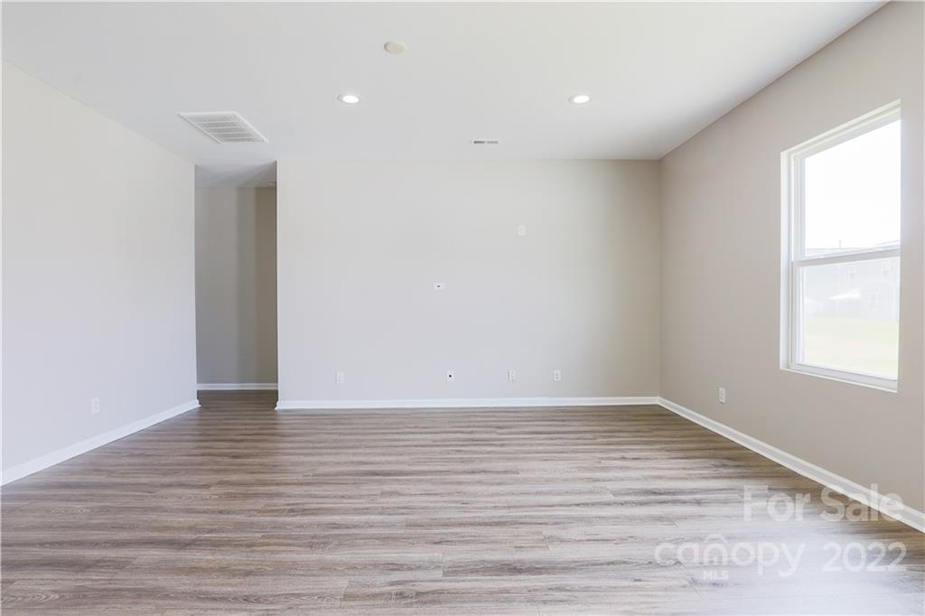 12507 Bending Branch Road Charlotte, NC 28227 - Photo 11 of 23 a view of an empty room with wooden floor and a window